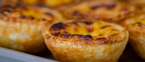 A tray of Portuguese egg tarts with a golden-brown crust.