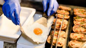 A person cooking an egg on a griddle.