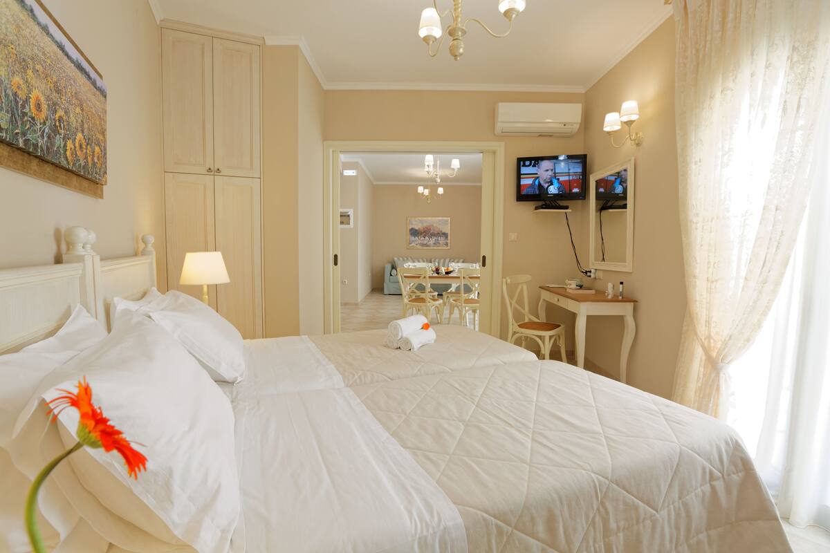 Una habitación de hotel con una cama grande, un escritorio, una silla y un televisor.