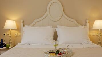A neatly made bed with white linens, two bedside lamps, and a tray with breakfast items.