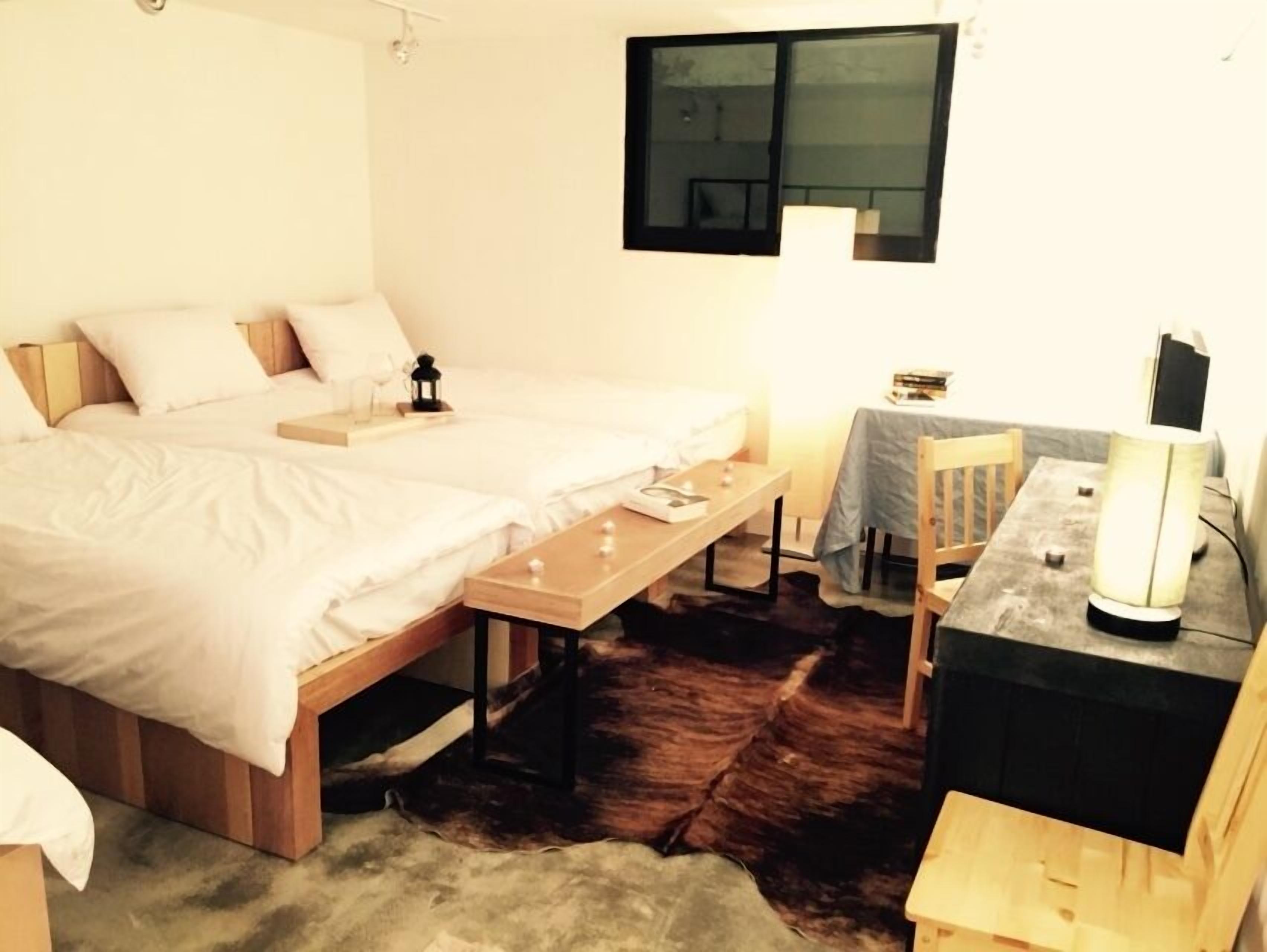 Ein Zimmer mit einem Bett, einem Schreibtisch, einem Stuhl und einem Tisch.