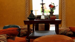 Una habitación con una mesa de madera, un sofá y un ventanal con vistas.