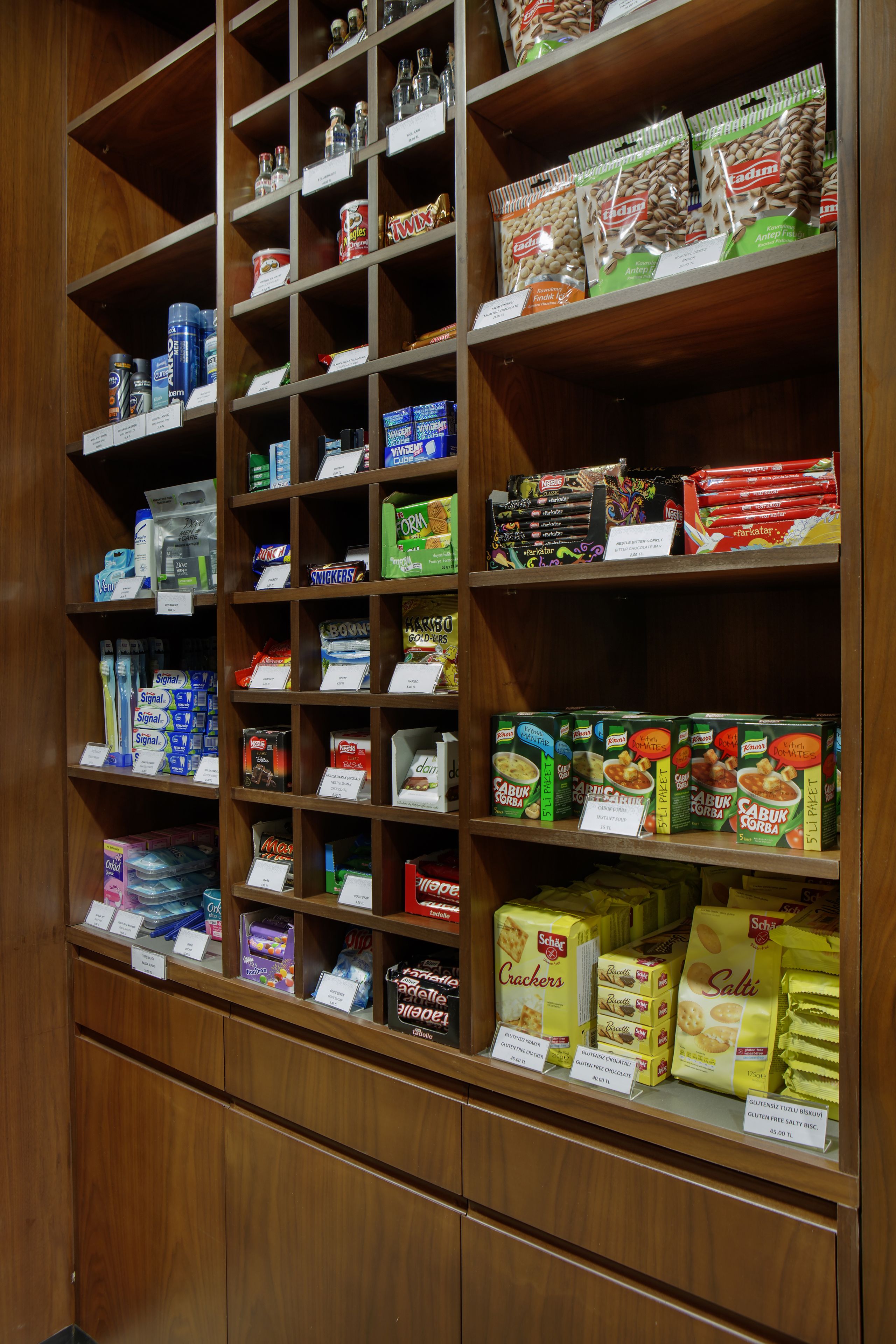 A grocery store with shelves stocked with various food items and price tags.