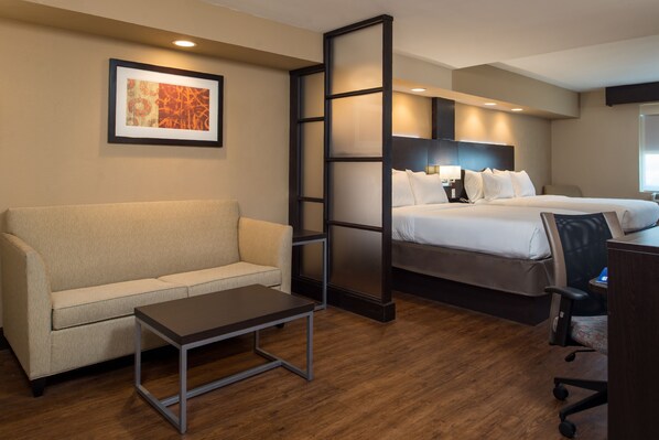 Una habitación de hotel con cama, sofá, escritorio y una silla.