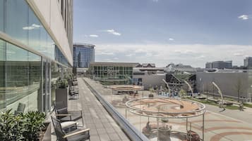 A modern building with large windows, outdoor seating, and a circular plaza.