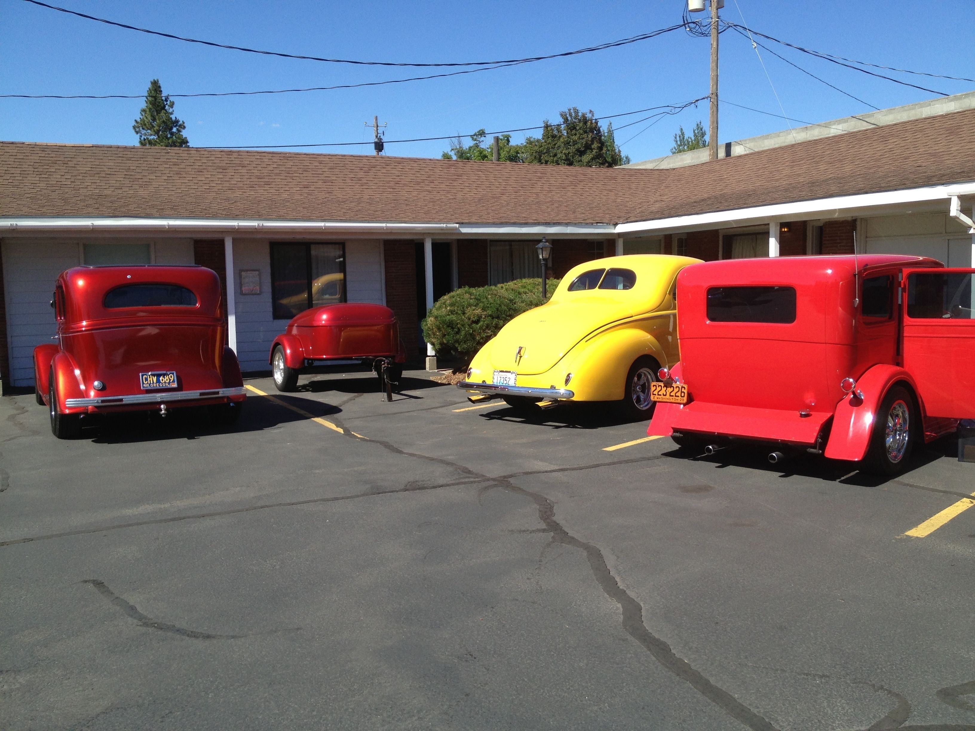 Ein Motel mit drei Oldtimern vor der Fassade.