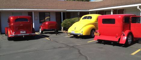 Un motel con tres coches antiguos estacionados al frente.