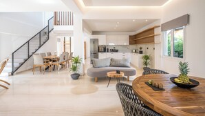 A modern open-plan living space with a dining area, kitchen, and staircase. - Stella Palace Aqua Park Resort (Hersonissos)
