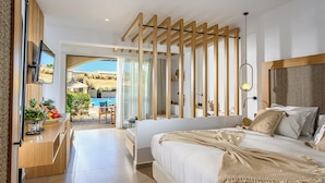 A modern bedroom with a large bed, wooden ceiling beams, a TV, and a view of a pool and outdoor area. - Stella Palace Aqua Park Resort (Hersonissos)
