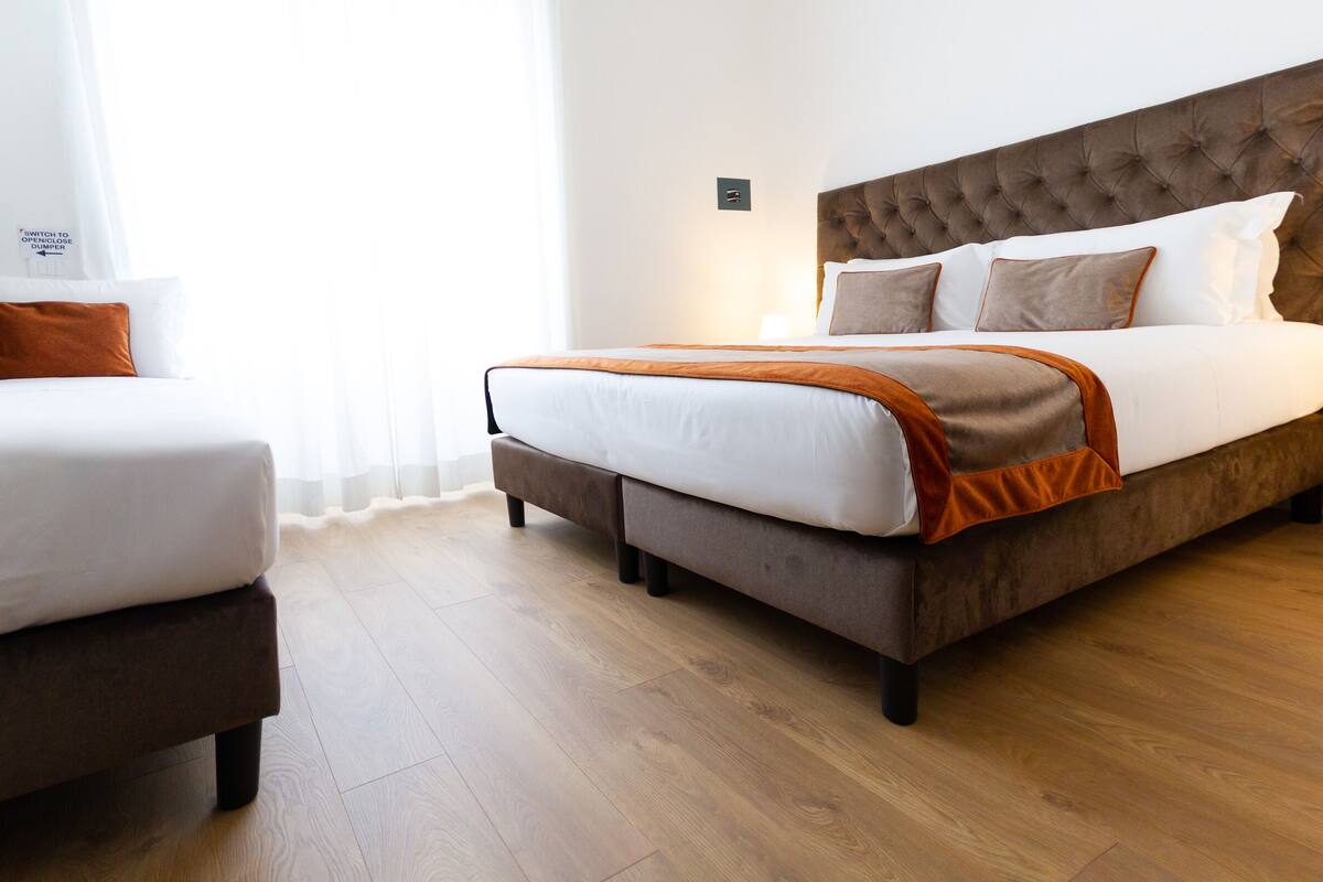 Una habitación de hotel con cama, sofá y mesita de noche.