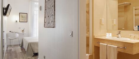 A modern bathroom with a large mirror, a sink, and a towel rack.