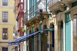 Un immeuble doté de nombreux balcons, un lampadaire et une enseigne indiquant «Hôtel Ibérico».