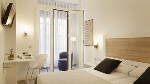 A hotel room with a bed, a desk, a chair, and a door leading to a balcony. - Hotel Santa Rosa, Blue Hoteles (Gijon)