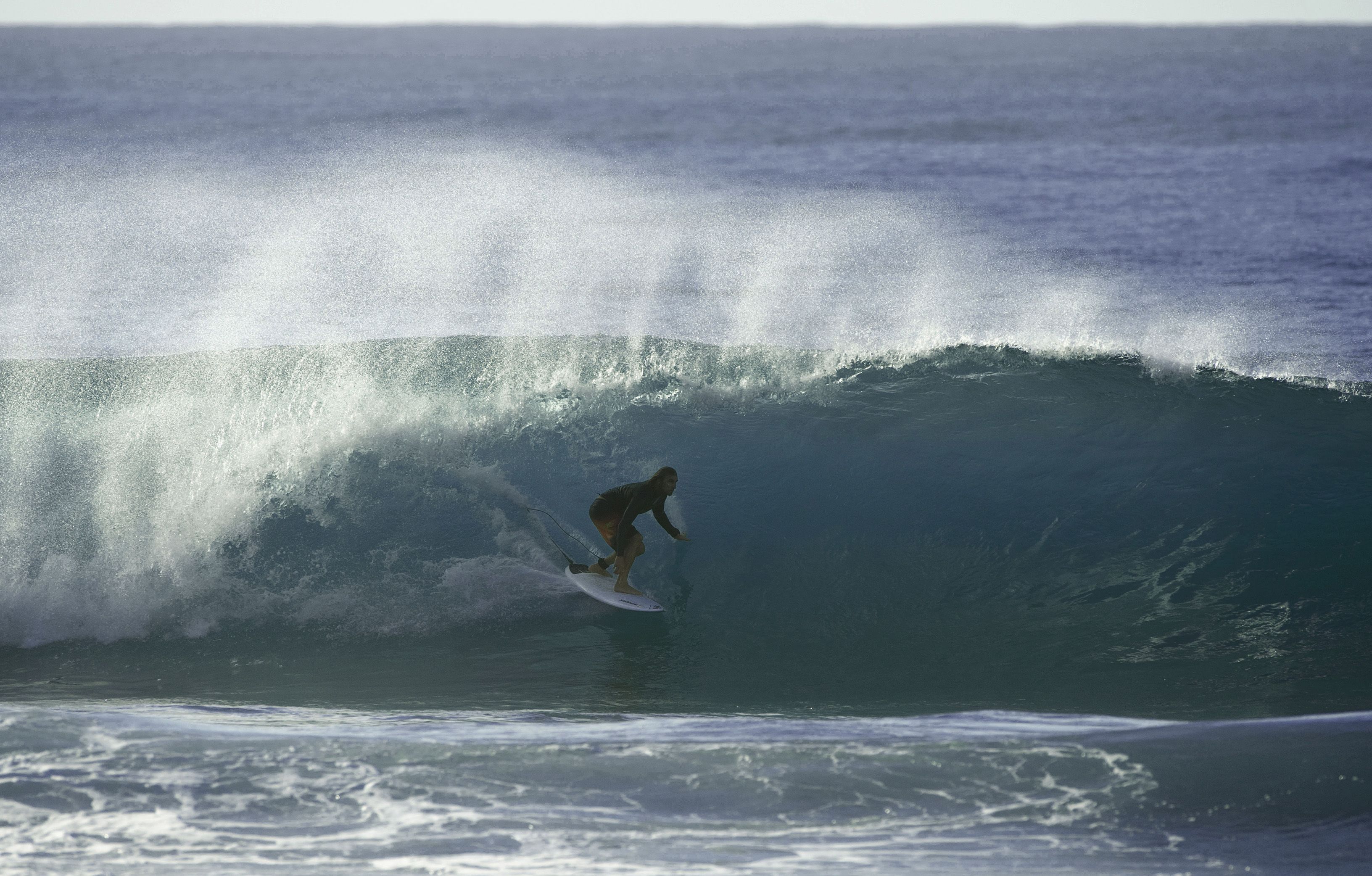 Un surfista cavalca un'onda alta nell'oceano.