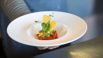 Une assiette blanche contenant un plat, tenue par une personne.