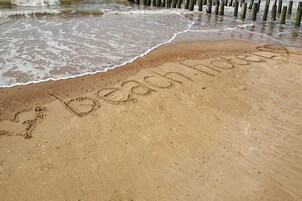 Ein Strand mit dem Wort "Beachside" im Sand geschrieben.