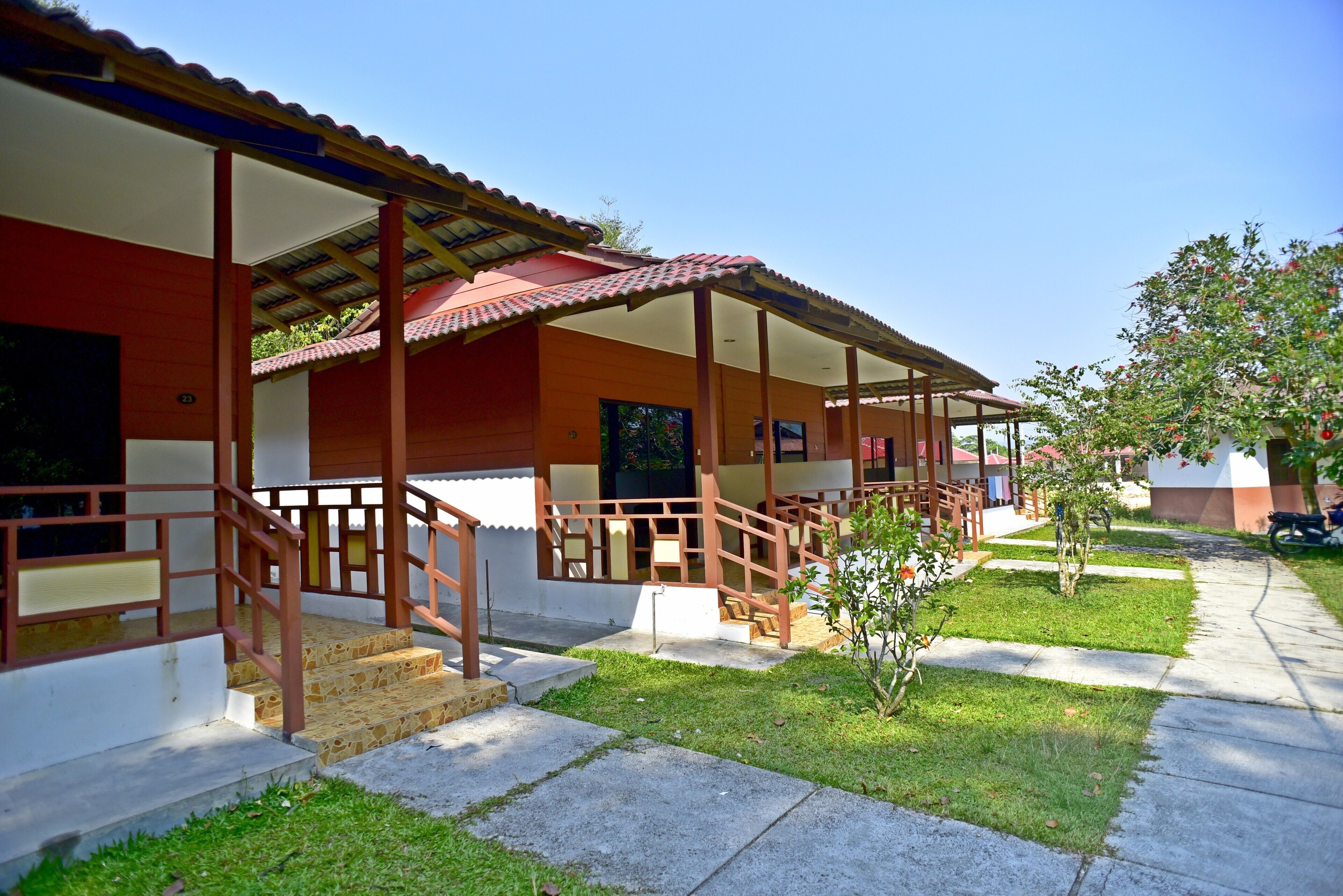 A building with a covered porch, steps leading to the entrance, and a small garden area.