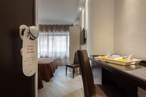 A hotel room with a bed, a chair, a desk, and a TV. - Sol Romae (Rome)