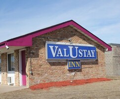 Un edificio de ladrillo con un letrero que dice 'VALUSTAY INN'.