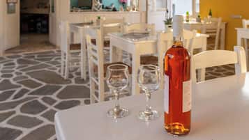 A dining area with a table, two wine glasses, and a bottle of wine.
