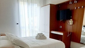 A hotel room with two beds, a TV, a telephone, and a desk. - Hotel Brotas (Rimini)