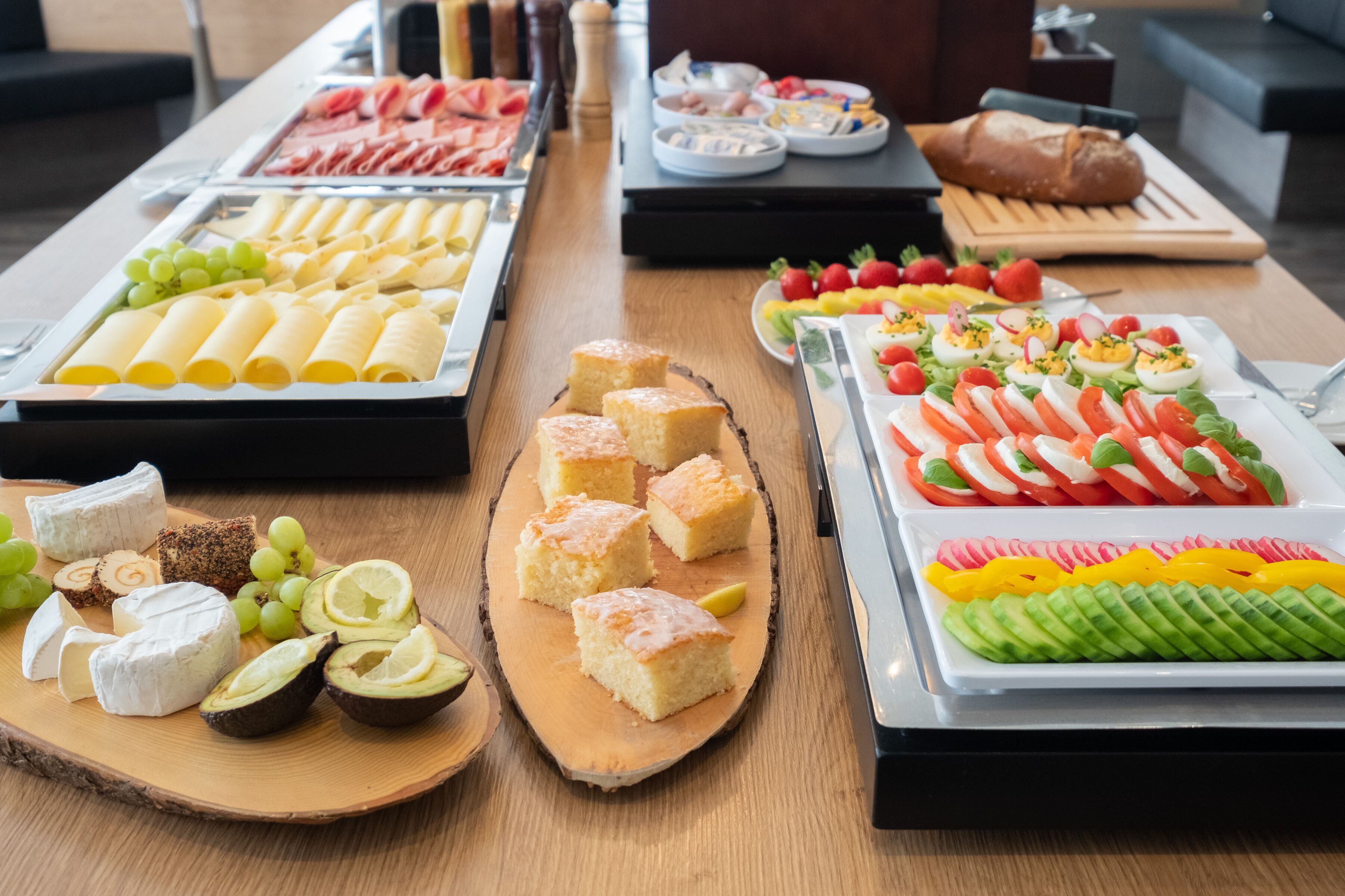 A buffet with various food items including cheese, bread, and fruit.