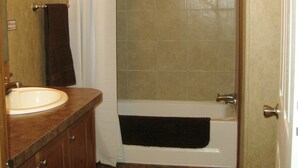A bathroom with a sink, a shower, and a bathtub. - Eagle Ford Lodging (Pleasanton)
