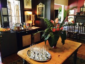 A bar area with a tray of empty glasses, a decorative plant, and a chalkboard menu listing dinner options.