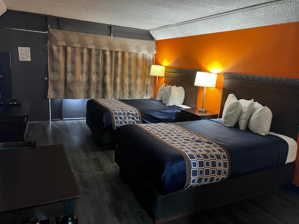 Een hotelkamer met twee bedden, een bureau en een televisie.
