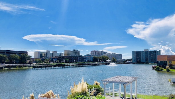 A waterfront view with a gazebo, a pier, and buildings in the background. - White Marlin Inn (Virginia Beach)