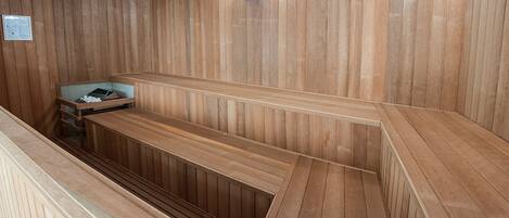 Un sauna en bois avec des bancs et une petite table.