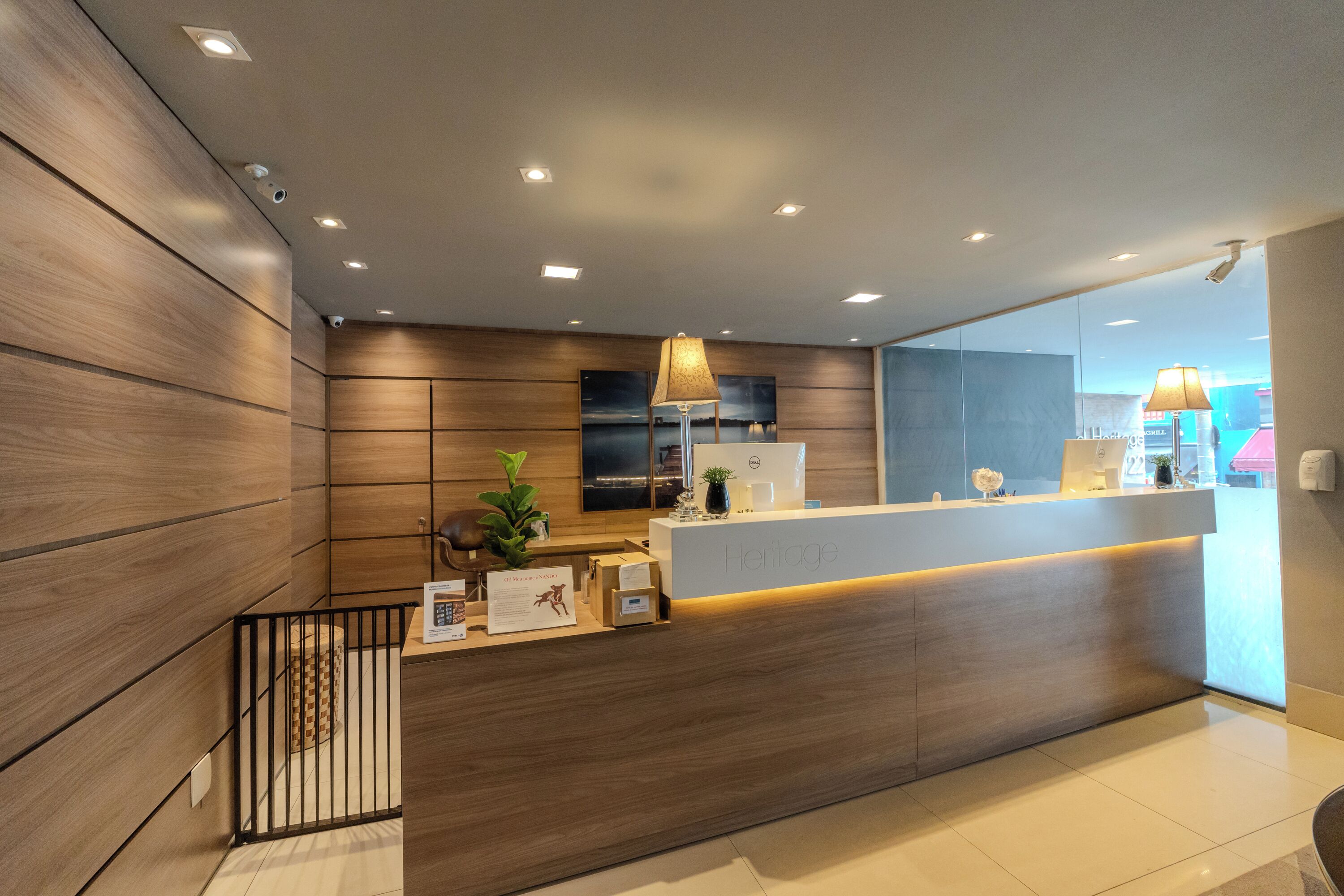 A modern reception area with a wooden reception desk, a potted plant, and a sign indicating a heritage theme.