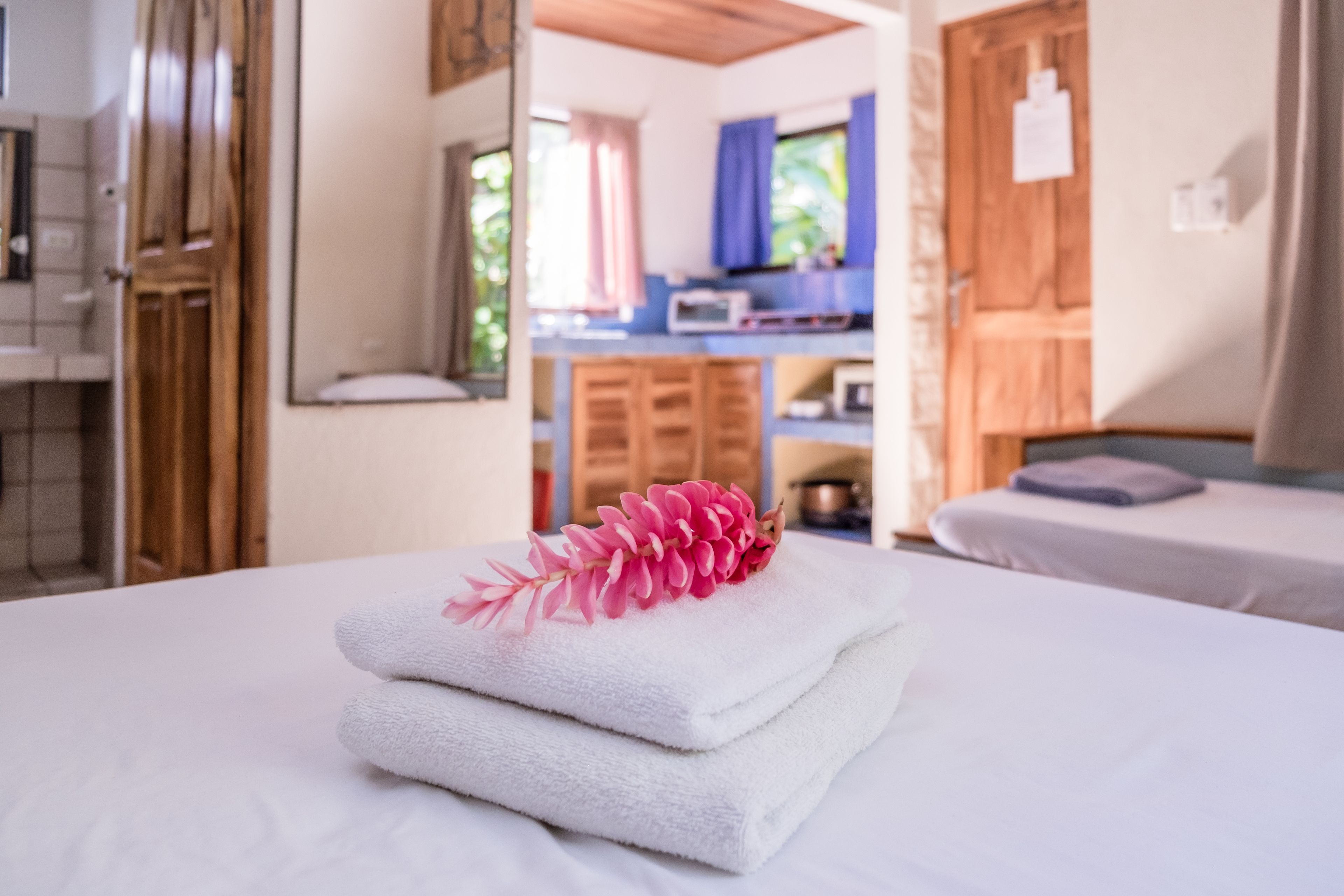 A hotel room with a bed, a bathroom, and a kitchenette.