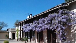 A building with a traditional architectural style, featuring a tiled roof and a covered porch.