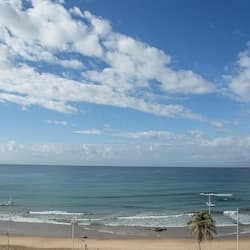 Enjoy a serene beach experience with gentle waves lapping at the shore.