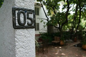 Un número de casa '05' en una pared con textura.