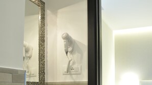 Uma casa de banho moderna com uma pia, espelho e porta-toalhas.