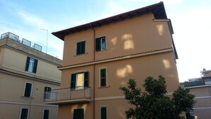 Um edifício de vários andares com teto plano e varanda no segundo pavimento.