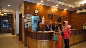 A reception desk with wooden paneling, a clock, and a sign for 'Mediterranean Hotel'. - Meldrum Hotel (Johor Bahru)