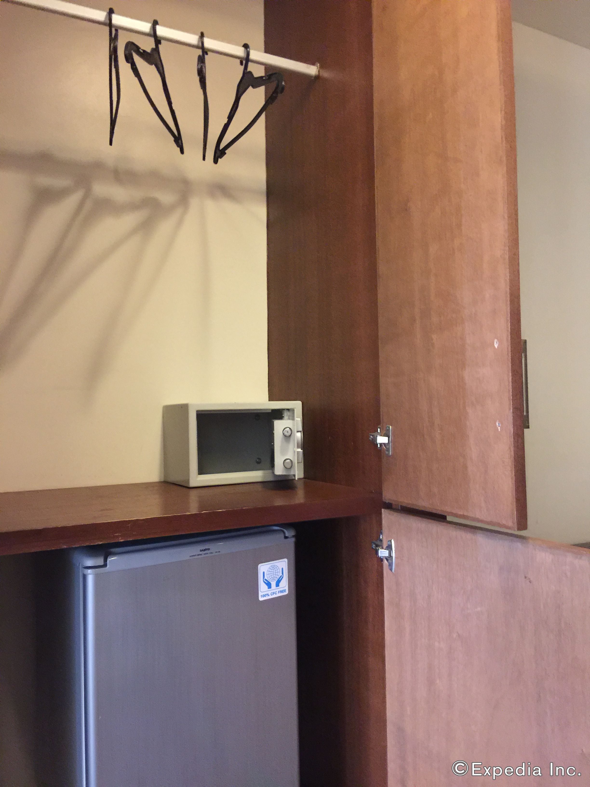 Una kitchenette equipada con microondas, refrigerador y ganchos para colgar.
