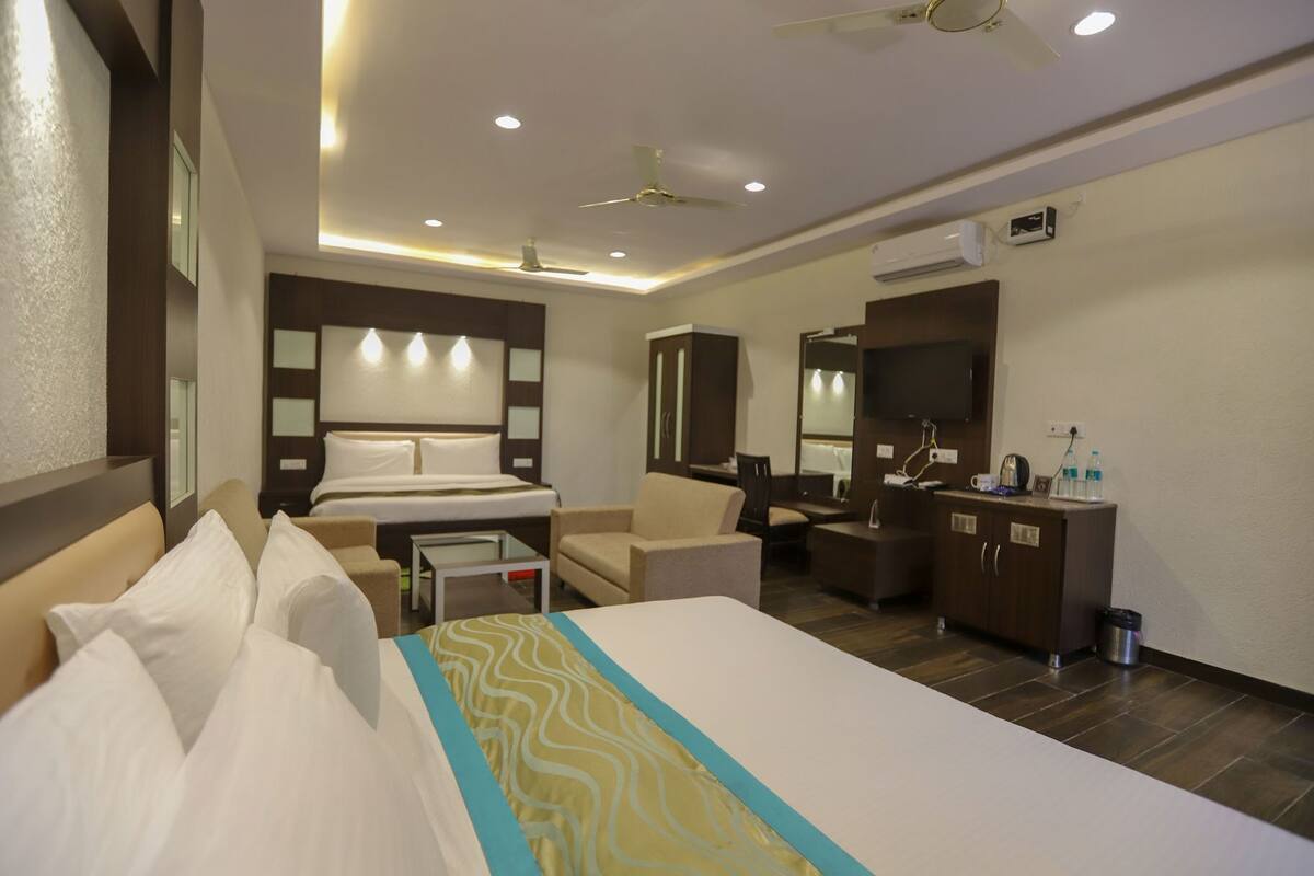 Ein Hotelzimmer mit Bett, Schreibtisch, Stuhl, Spiegel und Deckenventilator.