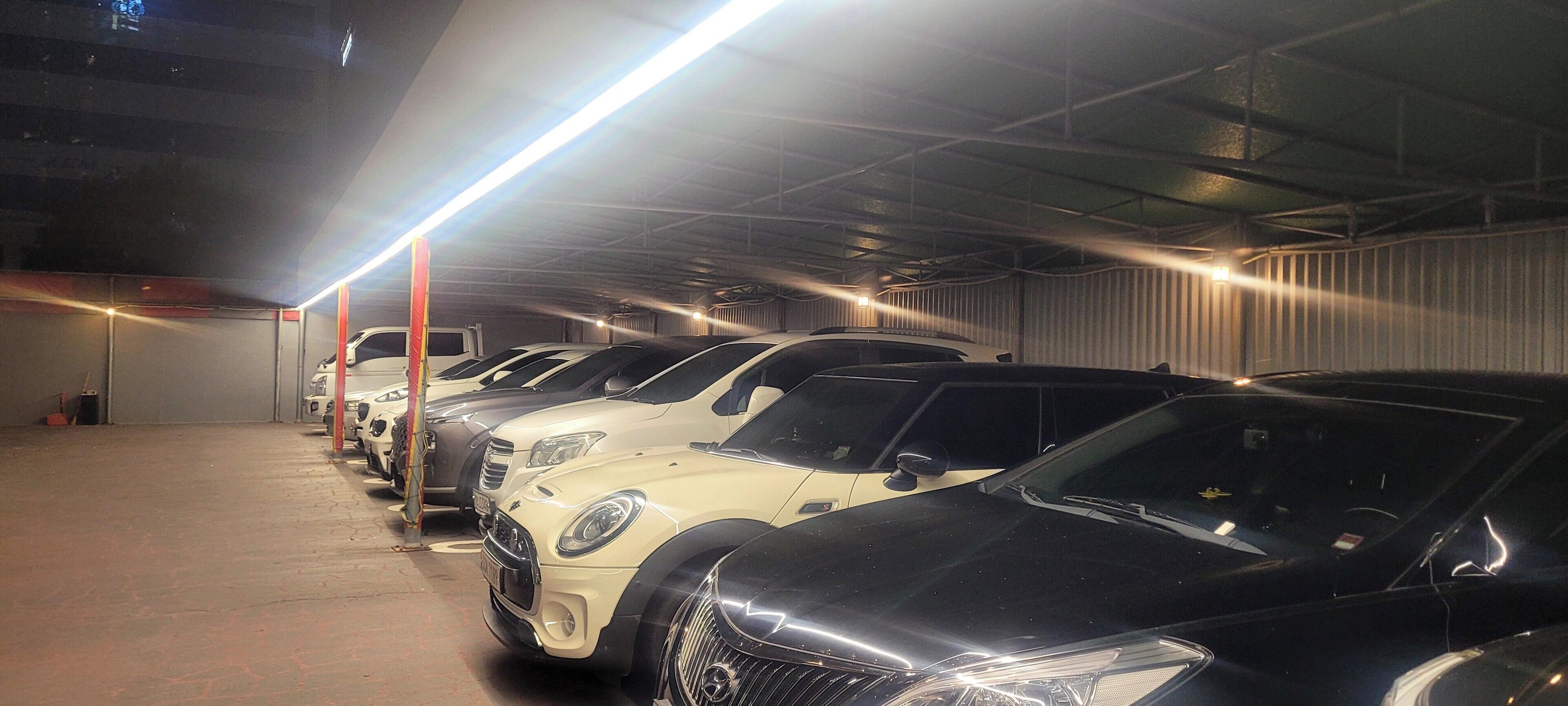 A parking garage with multiple cars parked in rows.