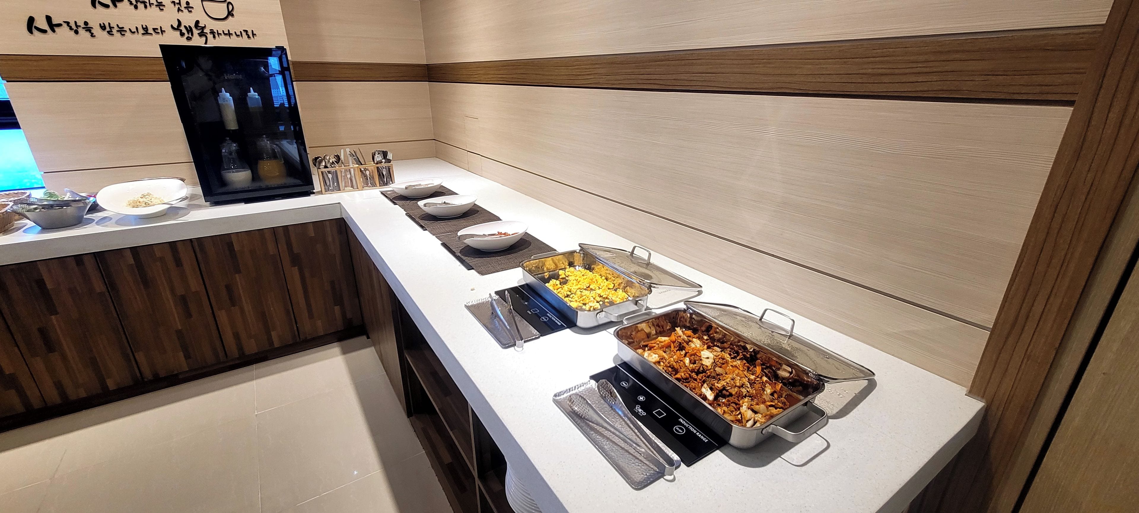 Uma mesa de buffet com diversos alimentos e acompanhamentos.