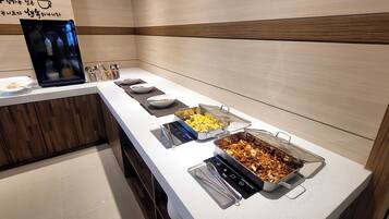 Uma mesa de buffet com diversos alimentos e acompanhamentos.