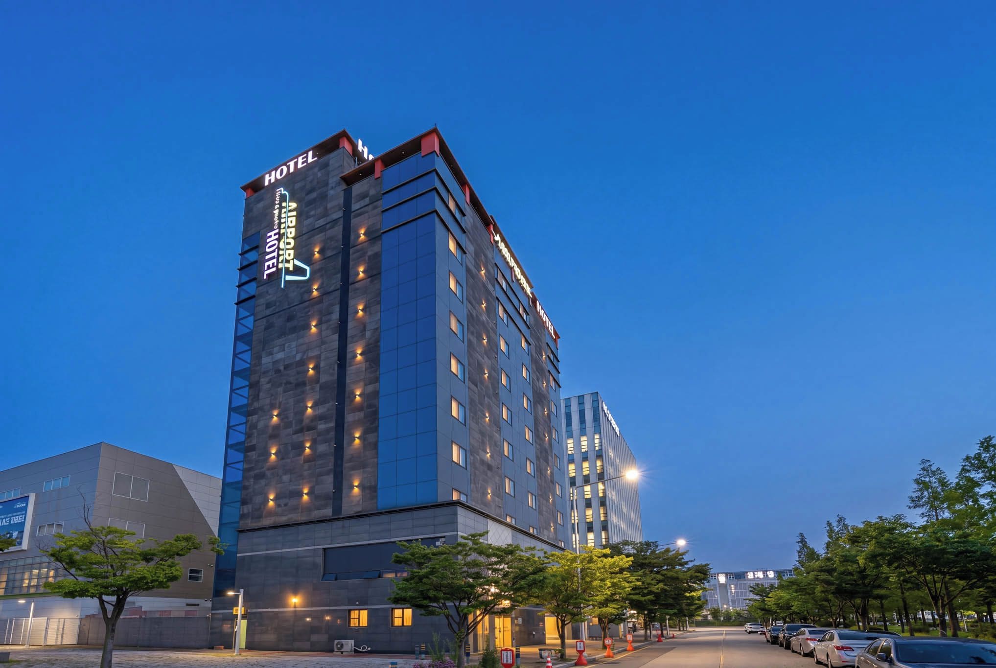 A modern hotel building with a prominent sign indicating it is an airport hotel.
