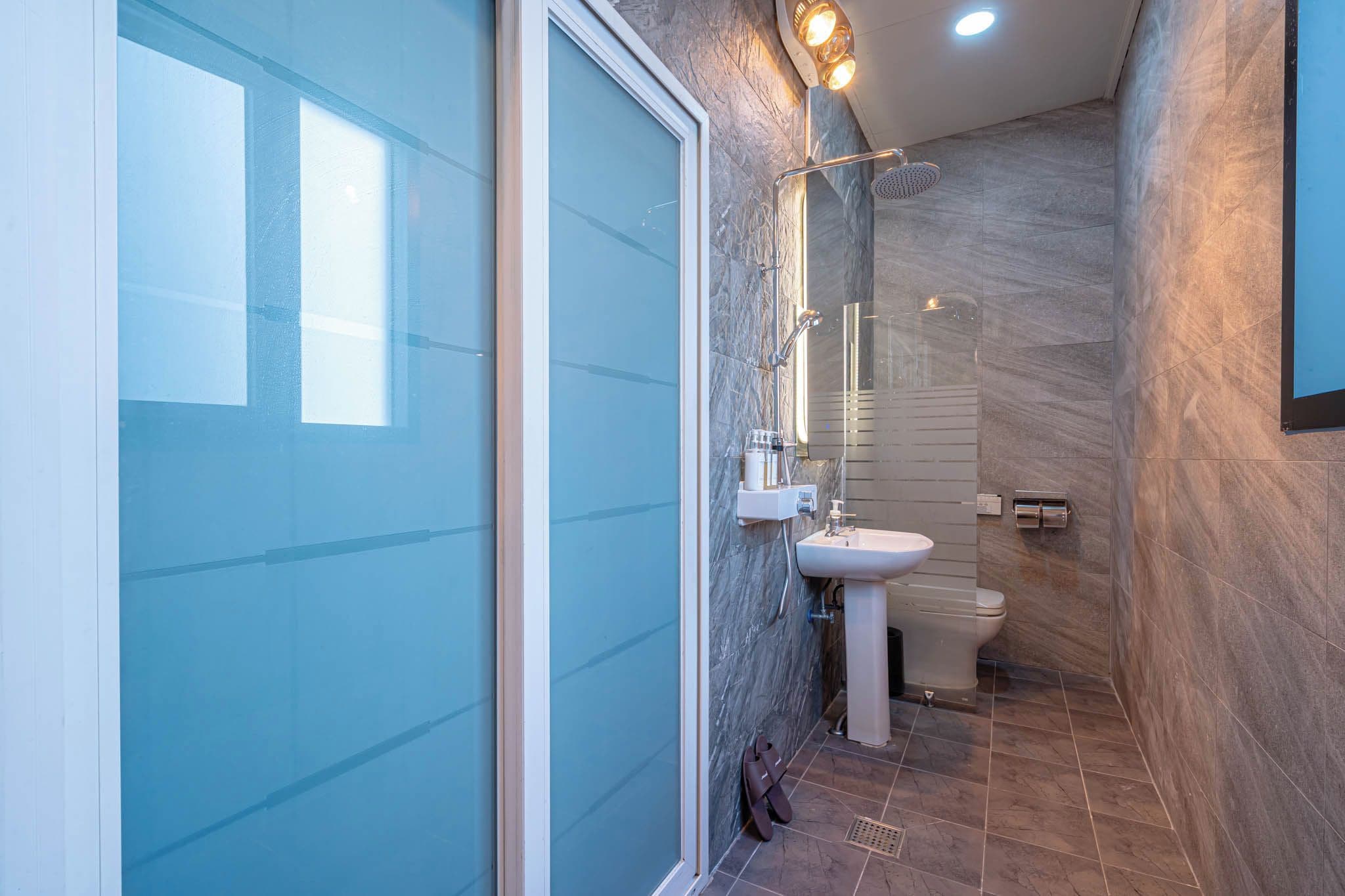 Une salle de bain moderne avec une douche à parois de verre, un lavabo et des toilettes.