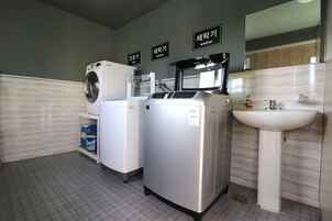 Un baño moderno con lavadora, secadora y lavamanos.