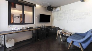 A modern kitchen with a large window, a flat-screen TV, and a wall with business-related words. - 2 Heaven Hotel (Busan)