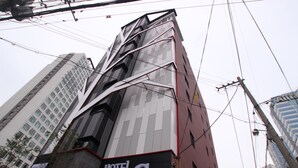A modern hotel with a prominent 'HOTEL G7' sign, featuring a unique architectural design with angular lines and a mix of glass and brick facades. - G7 Hotel (Busan)