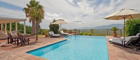 Piscine extérieure, parasols de plage, chaises longues